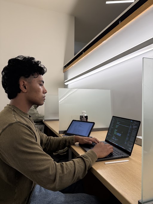Md Almasrafi, Lead Data Scientist at modSTORAGE, working on a laptop at a study desk.